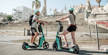 Dos personas con patinetes eléctricos de Tier.