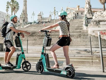 Dos personas con patinetes eléctricos de Tier.