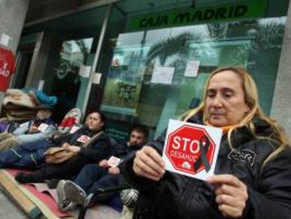 Miembros de la plataforma Stop Desahucios de la acampada Bankia Alicante cumplen 32 días de protesta a las puertas de una oficina de Caja Madrid en la avenida de la estación de Alicante.EFE/Archivo
