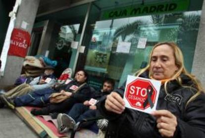 Miembros de la plataforma Stop Desahucios de la acampada Bankia Alicante cumplen 32 días de protesta a las puertas de una oficina de Caja Madrid en la avenida de la estación de Alicante.EFE/Archivo