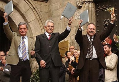 Los tres líderes, aplaudidos por el público a su salida del Salón del Tinell con el pacto en alto.