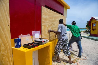 Uns veïns d'Orient Bay, illa francesa d'ultramar de Saint-Martin, es preparen per a l'huracà col·locant taulons.