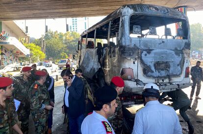 Miembros del Ejército sirio observan un autobús atacado con artefactos explosivos en Damasco, Siria, este miércoles.