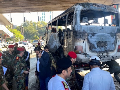 Miembros del Ejército sirio observan un autobús atacado con artefactos explosivos en Damasco, Siria, este miércoles.