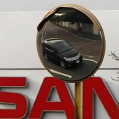 Un coche de Nissan se ve reflejado en un espejo en la fachada de la fábrica de coches