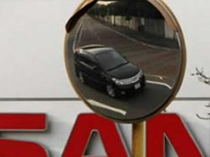 Un coche de Nissan se ve reflejado en un espejo en la fachada de la fábrica de coches