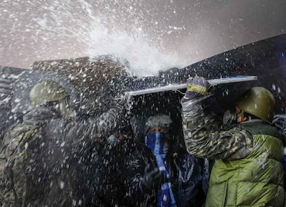 Un camión de bomberos que intenta apagar las barricadas moja a los manifestantes que siguen concentrados en el centro de Kiev (Ucraniana), 23 de enero de 2014.