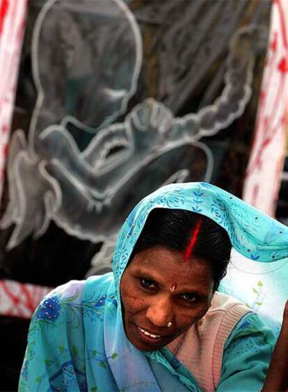 Una mujer, frente a un cartel de la campaña de CSR <i>Mi fuerza, mi hija</i> en Nueva Delhi.