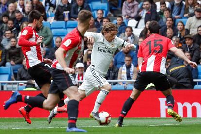  Luka Modric conduce el balón ante los jugadores del Athletic Íñigo Lekue (d) y Beñat Etxebarria (i). 