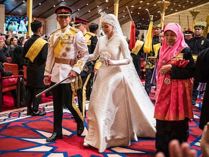 TOPSHOT - Prince Abdul Mateen (L) and Yang Mulia Anisha Rosnah walk down the aisle during their wedding reception at Istana Nurul Iman in Brunei's capital Bandar Seri Begawan on January 14, 2024. Lavish celebrations for the wedding of Brunei's Prince Abdul Mateen and his wife reached a climax on January 14 with a glittering ceremony attended by government leaders and blue-blooded guests from Asia and the Middle East. (Photo by IQBAL SELAMAT / AFP)