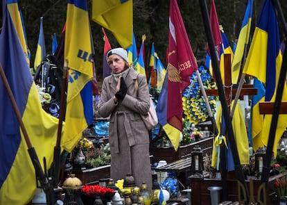 A woman visits the grave of her relative, a murdered Ukrainian soldier, on the second anniversary of Russia's invasion of Ukraine, in Lviv, on Saturday.