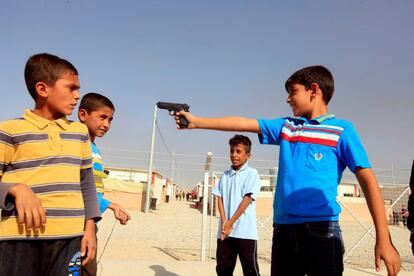 Un grupo de niños desplazados de la ciudad de Mosul juegan con una pistola en el campo de desplazados de Deepaka, Irak, el 20 de octubre.