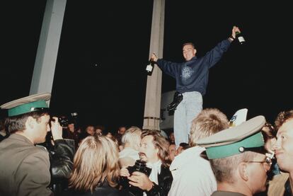 Un joven celebra la caída del muro de Berlín en Checkpoint Charlie, el 9 de noviembre de 1989.