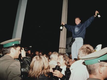 Un joven celebra la caída del muro de Berlín en Checkpoint Charlie, el 9 de noviembre de 1989.