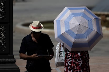 Sun protected tourists with a hat and umbrella, this Wednesday in Seville.