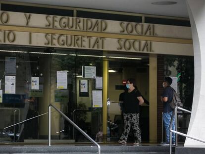 Varias personas esperan en las puertas de la oficina de Empleo y Seguridad Social de Barcelona.