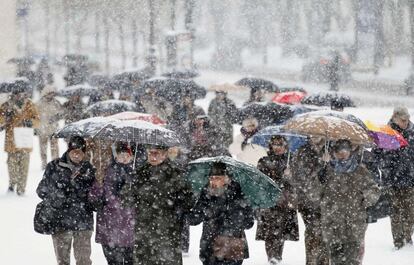 Un grupo de personas camina bajo la intensa nevada en un parque de Burgos.