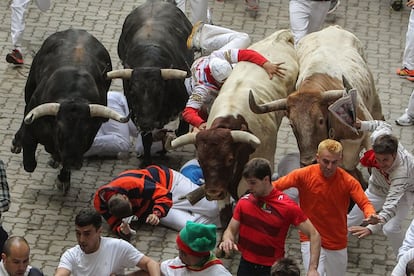 Los mozos corren delante de los toros de Garcigrande en el cuarto encierro de los Sanfermines 2014.