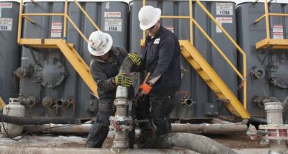 Dos operarios trabajan en una explotaci&oacute;n petrolera de Dakota del Norte.