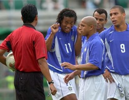 Ronaldinho, junto a Roberto Carlos, Cafú y Ronaldo, trata de convencer al árbitro de que no le expulse.