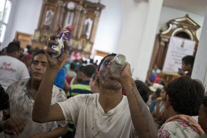 Un hombre bebe ron en una iglesia de Managua.