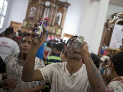 Un hombre bebe ron en una iglesia de Managua.