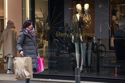 Una mujer pasa este viernes junto a un comercio del centro de Vitoria (Álava)