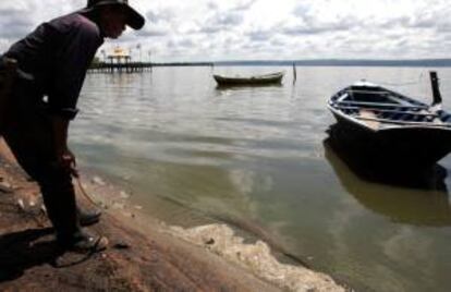 Un hombre observa el agua contaminada de la orilla del lago Ypacaraí en la localidad de Areguá (Paraguay). EFE/Archivo