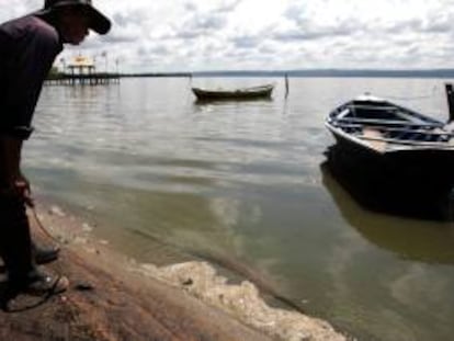 Un hombre observa el agua contaminada de la orilla del lago Ypacaraí en la localidad de Areguá (Paraguay). EFE/Archivo