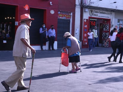 Dos adultos de la tercera edad caminan sobre un paseo peatonal en Cuernavaca, en el Estado de Morelos, el 8 de marzo de 2023.