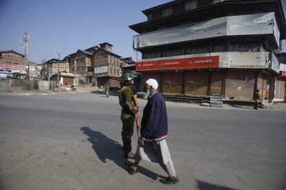 Un anciano camina frente a un soldado que hace guardia durante una huelga en Srinagar (India).