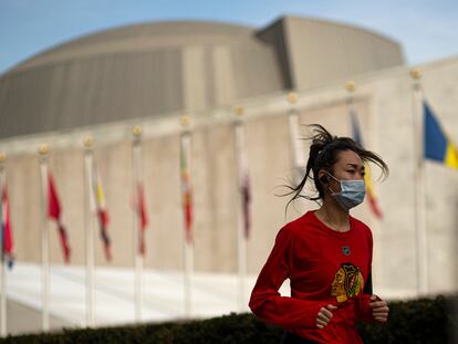 Una mujer corre con mascarilla frente al edificio de Naciones Unidas en Nueva York, Estados Unidos, este martes.