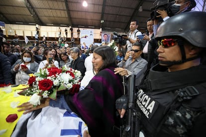 A police officer stands guard, as Tamia Villavicencio, daughter of Ecuadorean presidential candidate Fernando Villavicencio, a vocal critic of corruption and organized crime, reacts during a post-mortem tribute at Quito Exhibition Center, after Villavicencio was killed during a campaign event, in Quito, Ecuador August 11, 2023.REUTERS/Henry Romero