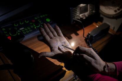 En el puente de mando, un miembro de la tripulación anota las coordenadas en su mano, preparándose para responder a un posible caso de una embarcación en peligro después de recibir un aviso por radio.