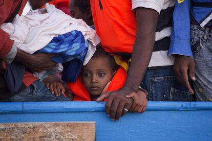 Un niño pequeño casi aplastado entre los más de 700 migrantes de una patera espera a ser rescatado.