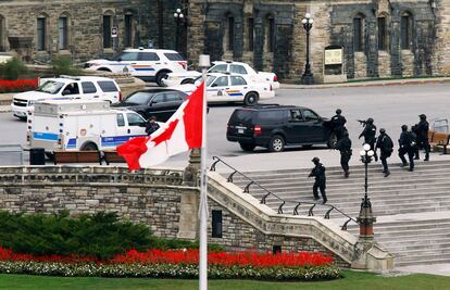 O suposto autor dos disparos em Ottawa contra um soldado e do ataque ao edifício do Parlamento canadense foi abatido pela Policía, que investiga se outras duas pessoas participaram na ação. Na imagem, policiais no exterior do Parlamento de Ottawa (Canadá).