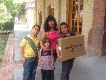 Una familia muestra la televisión regalada por el Gobierno.