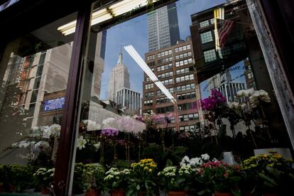 The Empire State Building is seen reflected on the window of a plant shop in Manhattan's flower district in New York, U.S., on Thursday, March 24, 2016. With an El Nino in the equatorial Pacific, winter across the contiguous U.S. was the warmest in history, and new daily high temperatures were posted last week in Philadelphia, Trenton, Boston and New York's Central Park. Photographer: Michael Nagle/Bloomberg