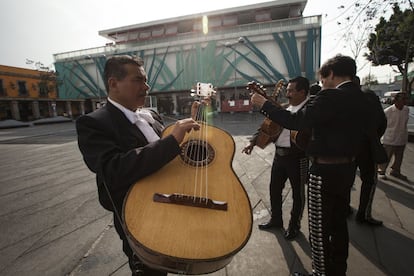 Un grupo de mariachis espera por clientes en la Plaza Garibaldi (México, D.F.). Al fondo se observa el Museo del Tequila y el Mezcal a la entrada de la Plaza.