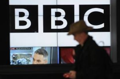 Un viandante pasa delante de una pantalla con imágenes de la BBC en Londres. EFE/Archivo