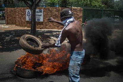 Un manifestante prende fuego a un neumático durante las protestas en Vereeniging (Sudáfrica).  