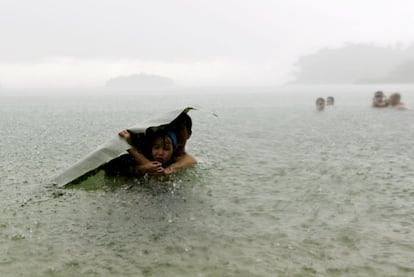 Gotas de lluvia, aguaceros, mares embravecidos o en calma, aguas cristalinas o contaminadas, para beber, para disfrutar.. Imágenes para reflexionar sobre la importancia de este elemento vital. En la imagen, bañistas bajo un intenso aguacero en la costa de ciudad de Colón en Panamá.