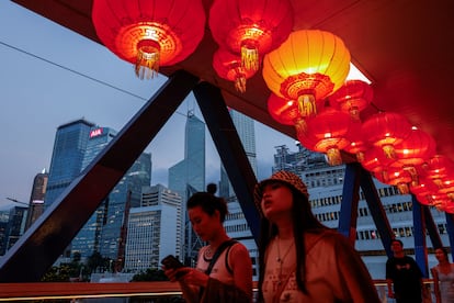 Unos ciudadanos pasean por un puente decorado en ocasión de día nacional de China, en Hong Kong.