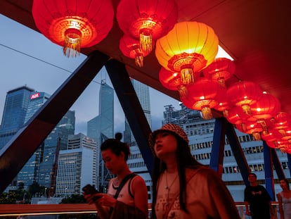 Unos ciudadanos pasean por un puente decorado en ocasión de día nacional de China, en Hong Kong.