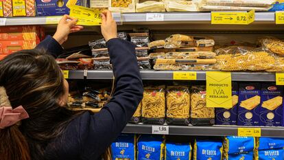 Una empleada de un supermercado colocando los precios de alimentos con el IVA rebajado.