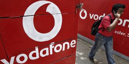 Usuario habla por el m&oacute;vil bajo una pared de Vodafone