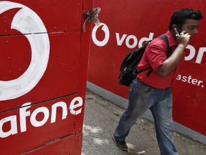 Usuario habla por el m&oacute;vil bajo una pared de Vodafone