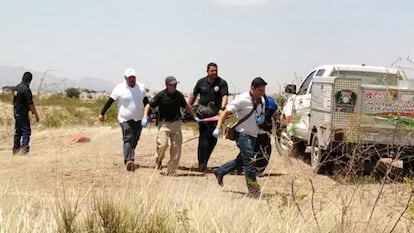 Authorities carry the body of six-year-old Christopher who was killed on the outskirts of Chihuahua.