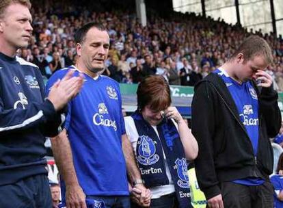 La madre de Rhys Jones llora, entre su marido y su hijo mayor, durante el homenaje que el club Everton rindió el sábado al niño.