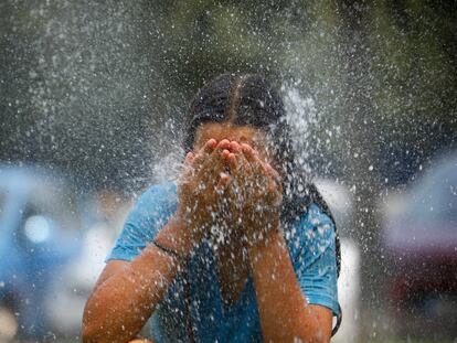 Una joven se refresca en una fuente de una calle de Córdoba, el viernes.